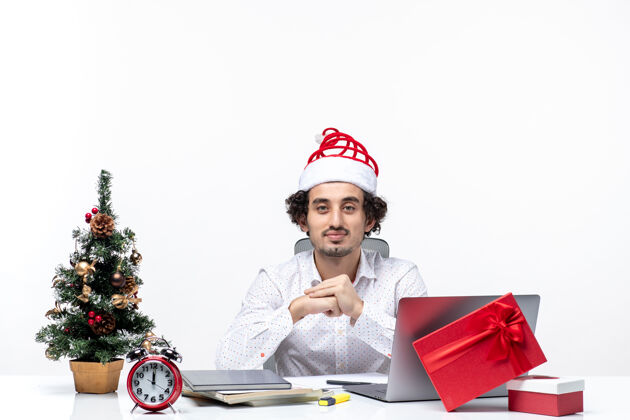 圣诞老人满意忙碌自豪的年轻商人与有趣的圣诞老人帽子庆祝圣诞节在办公室股票白色背景照片帽子年轻庆祝