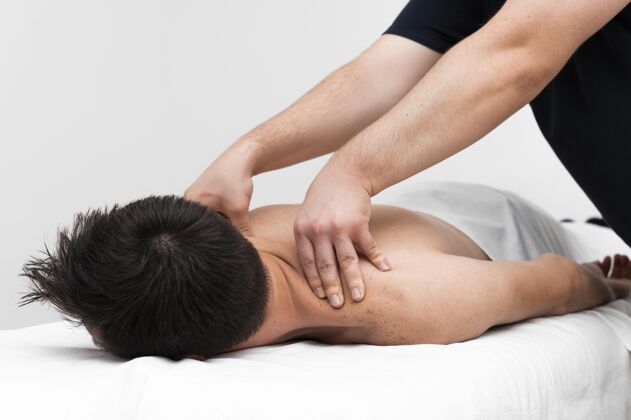 男性理疗师按摩男人的背部运动理疗补救