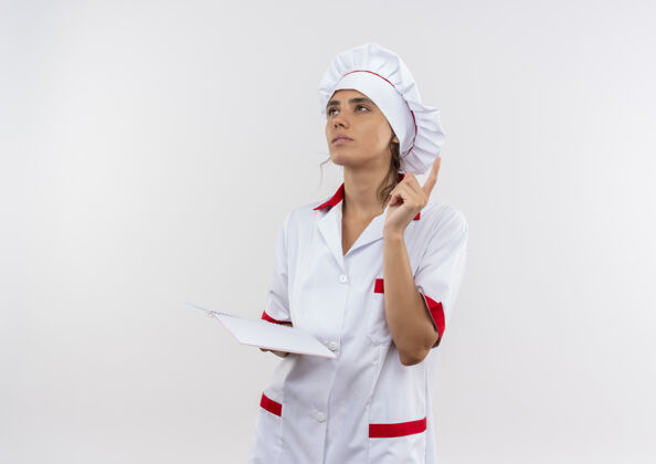 厨师看着一旁想着穿着厨师制服的年轻女厨师拿着笔记本点着找上了隔离的白色墙壁和复印空间制服边思考