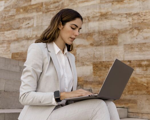 时尚优雅的女商人与智能手表工作在笔记本电脑户外个人水平行政人员
