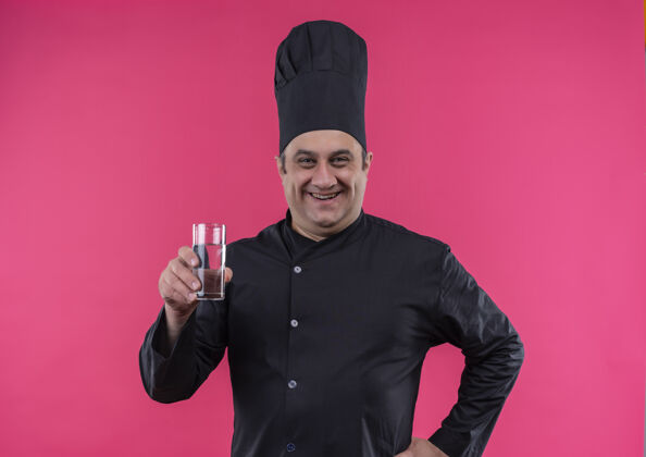 水微笑的中年男厨师 身着厨师制服 手里拿着一杯水男中年杯子