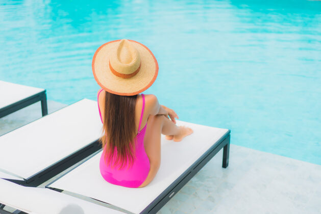 休闲肖像美丽的亚洲年轻女子放松微笑周围的室外游泳池在酒店度假村海滩水疗女性