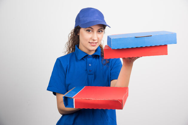 持有送比萨饼的女孩拿着三个白色背景的盒子高质量的照片帽子女孩送货