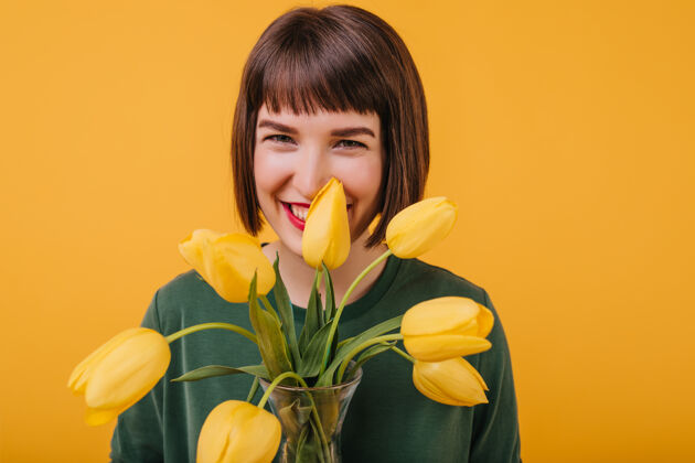 女性迷人的女人笑着拿着花用郁金香表达幸福的漂亮黑发女孩的肖像植物郁金香女士