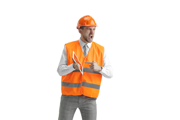 男人一个穿着建筑背心 戴着带石碑的橙色头盔的建筑工人专家工程头盔