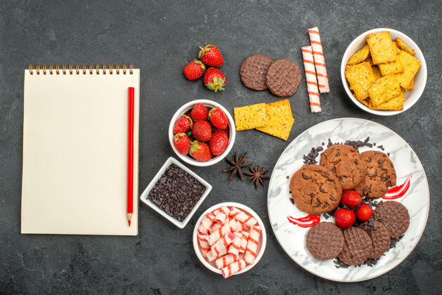 甜食俯视美味巧克力饼干与不同的零食对黑暗的背景甜饼干照片食物美味碗