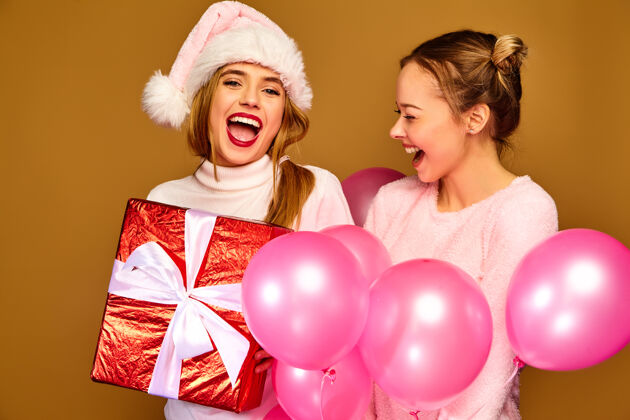 圣诞老人圣诞节带着大礼盒和粉色气球的模特们时尚友好青春