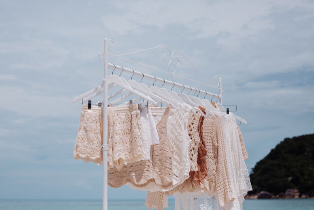 休闲在热带海滩上穿上时尚针织服装的落地衣架衣服衣架衣架