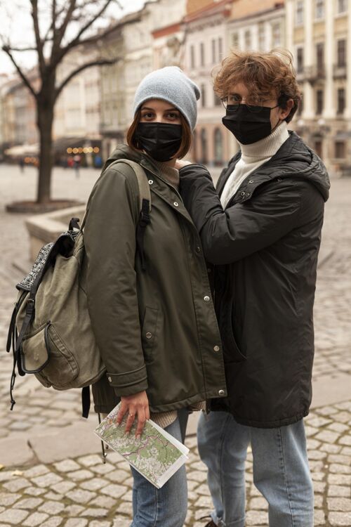 社会带着医用口罩在户外摆姿势的年轻夫妇面部医疗社区