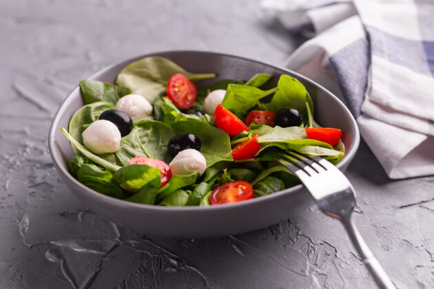 健康食品新鲜沙拉配莫扎里拉奶酪番茄和菠菜健康减肥食品菠菜餐碗