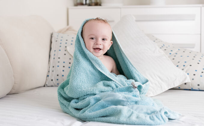小宝宝洗完澡 满脸笑容 全身裹着蓝色毛巾毛巾枕头房子