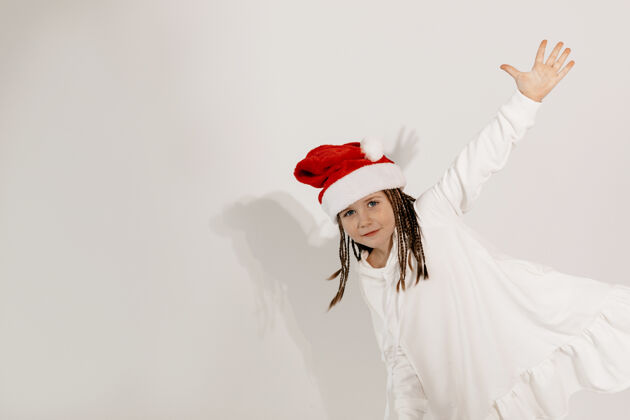 女孩有趣迷人的女孩在圣诞快乐心情圣诞帽愿望摆姿势美丽