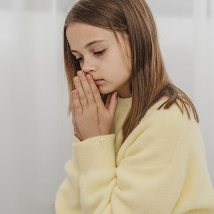 灵性小女孩在家祈祷的侧视图崇拜信仰女孩
